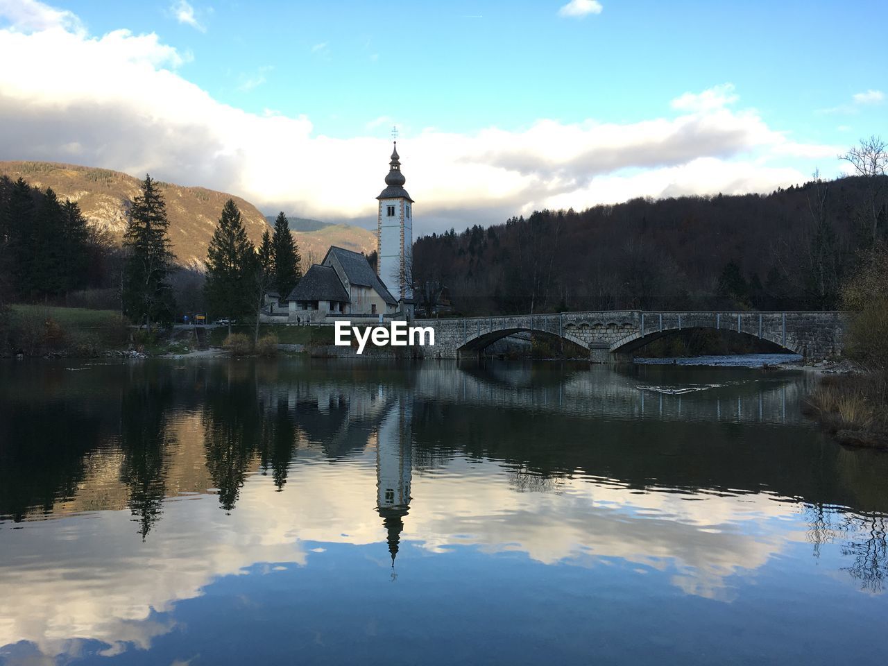 REFLECTION OF BUILDING AND TREES IN LAKE