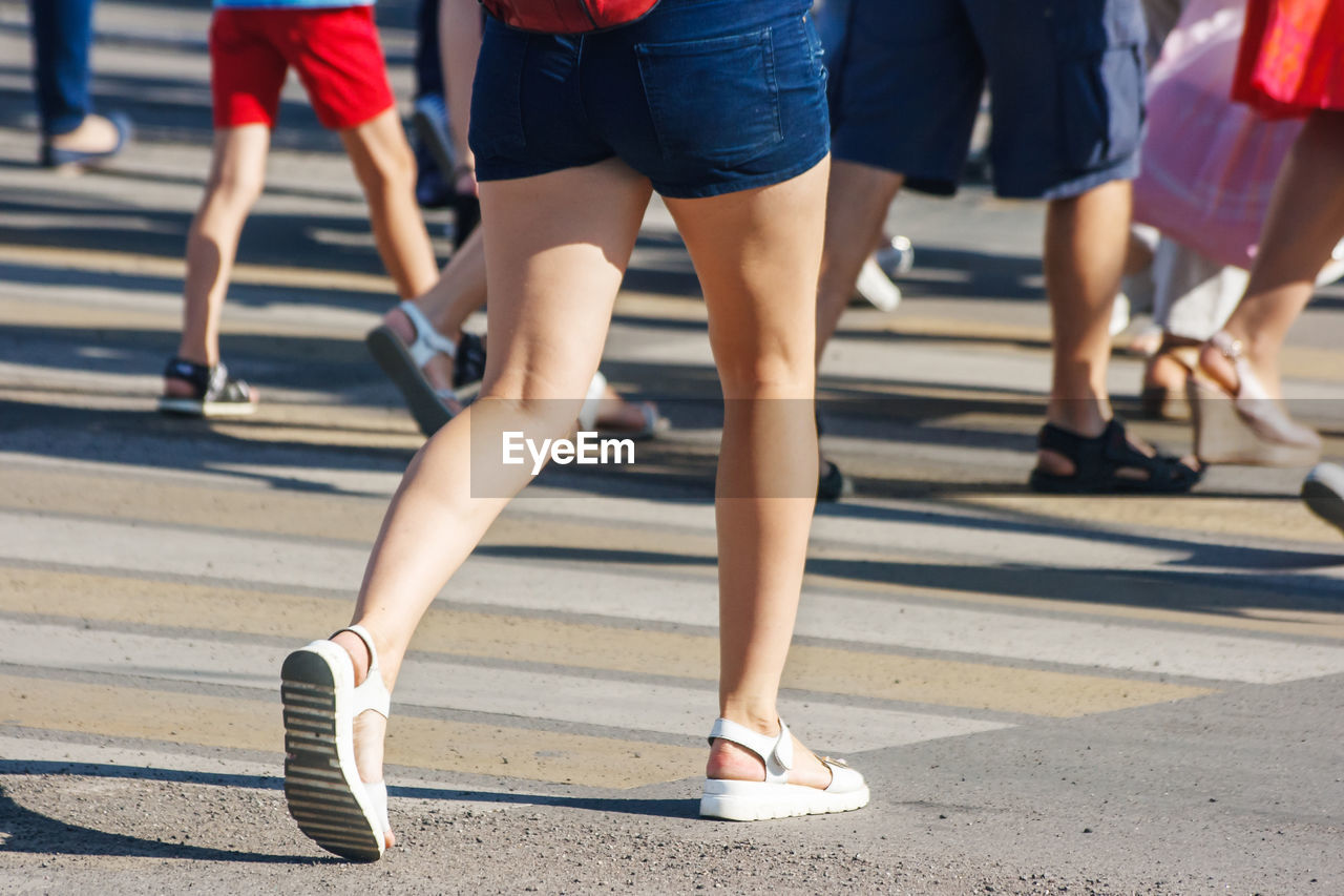 Low section of people walking on crosswalk