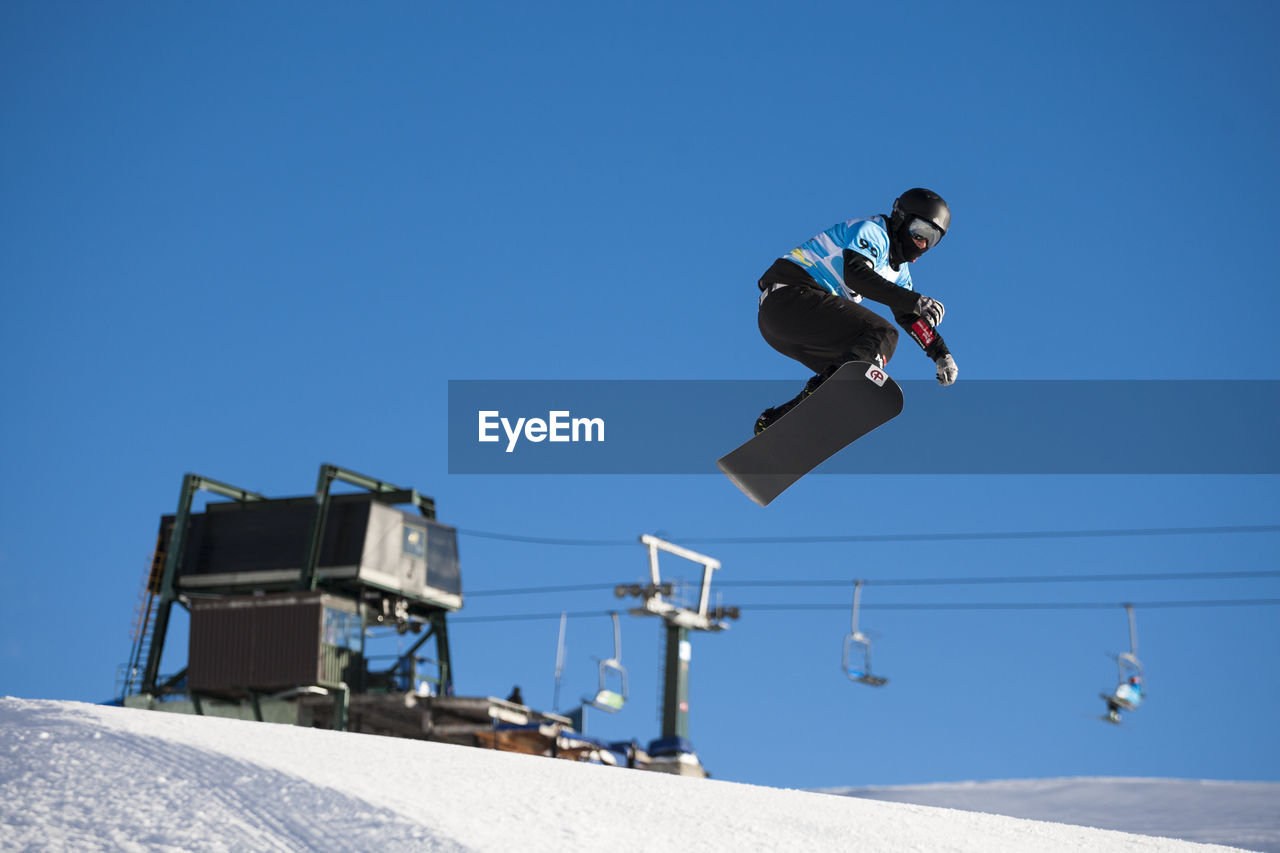Man snowboarding against sky