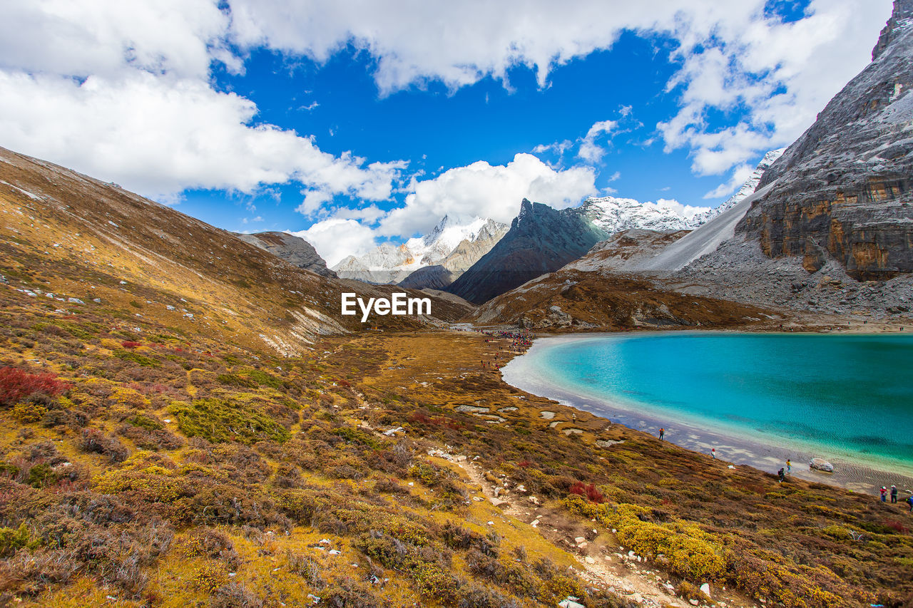 Scenic view of lake by mountains against sky