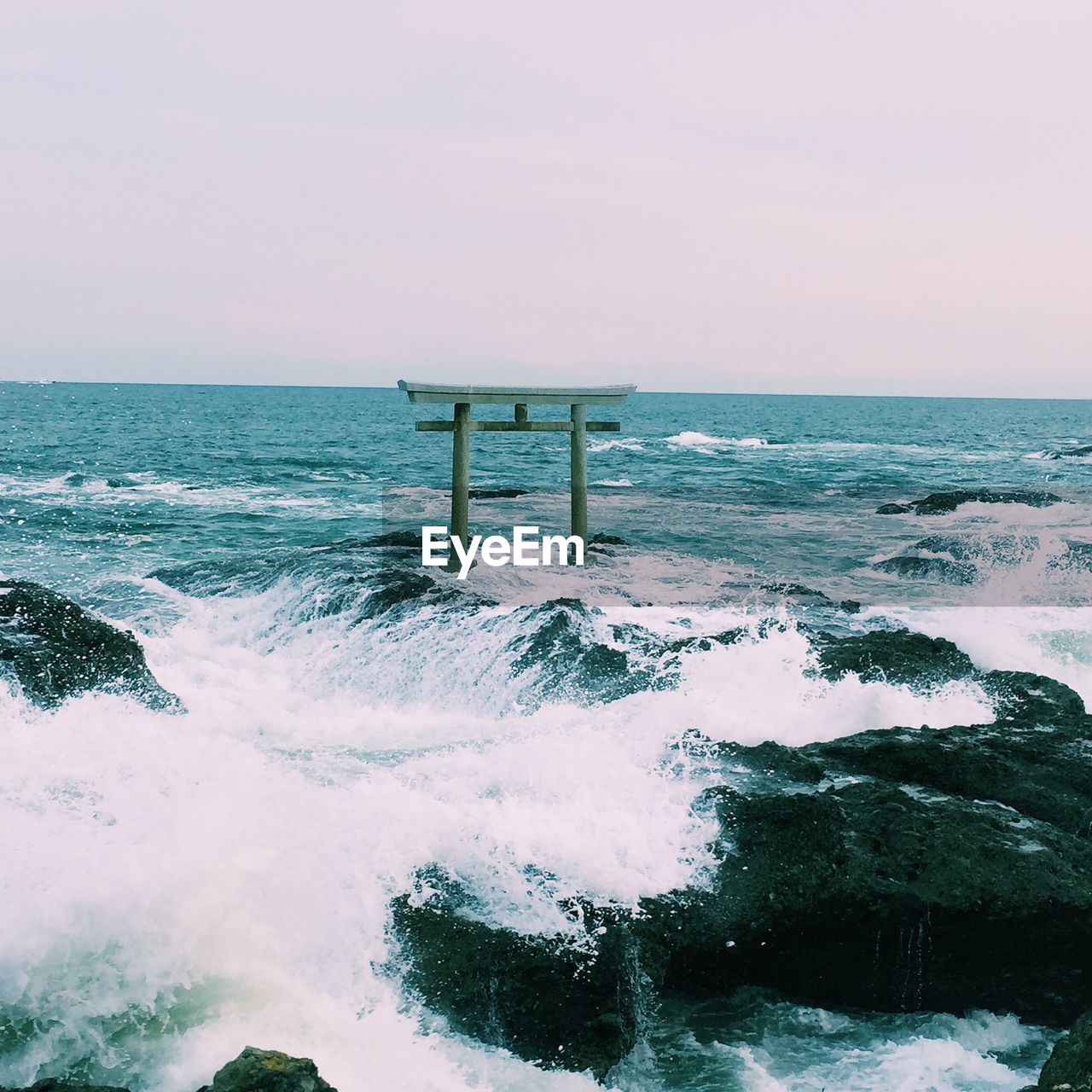 Torii gate in sea against sky