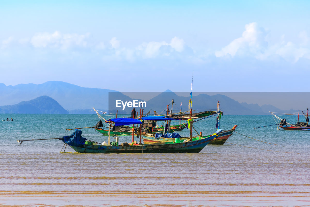 Boats moored in sea against sky