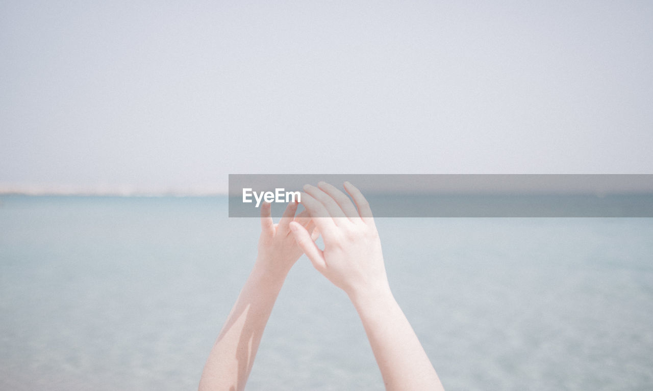 Cropped hands of woman at beach