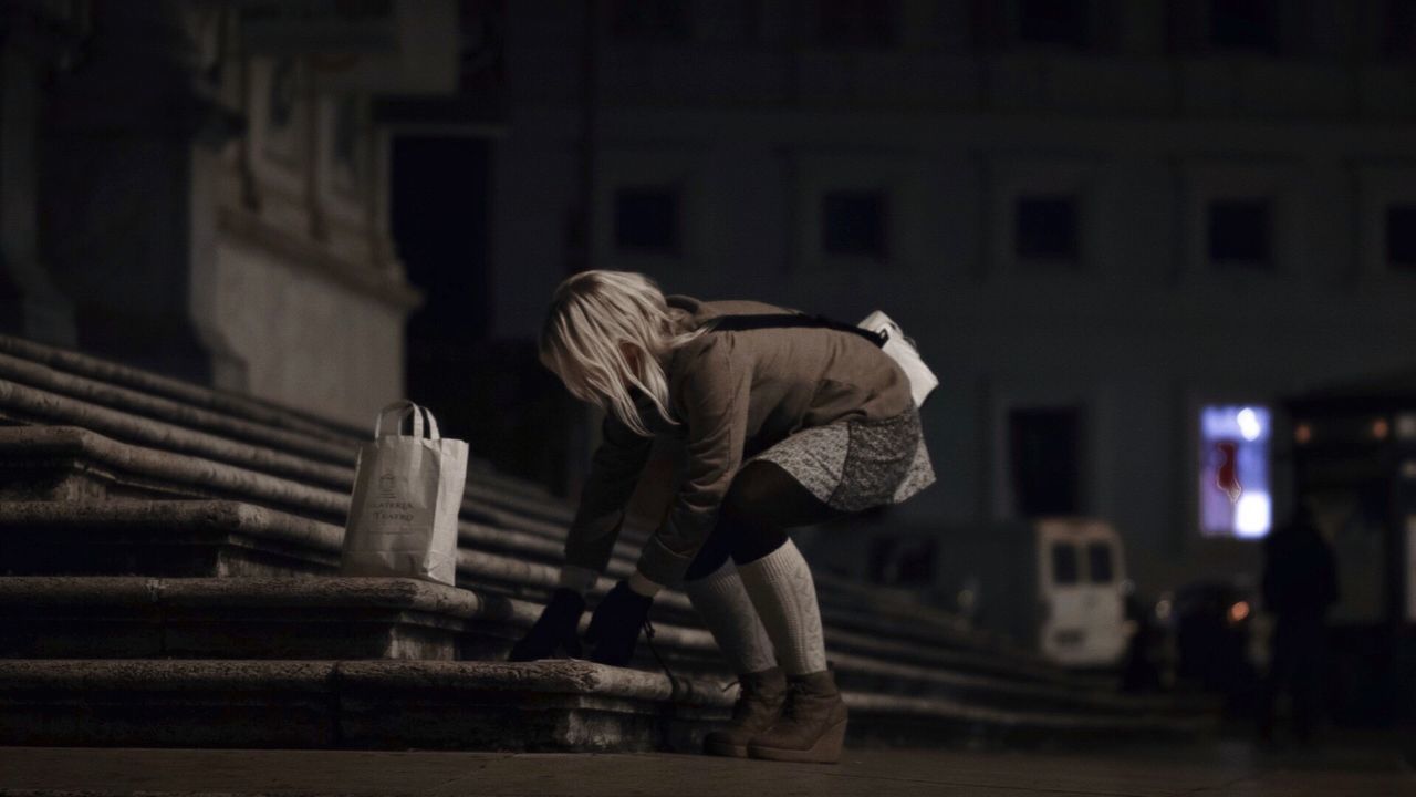 Full length of woman bending by steps at night