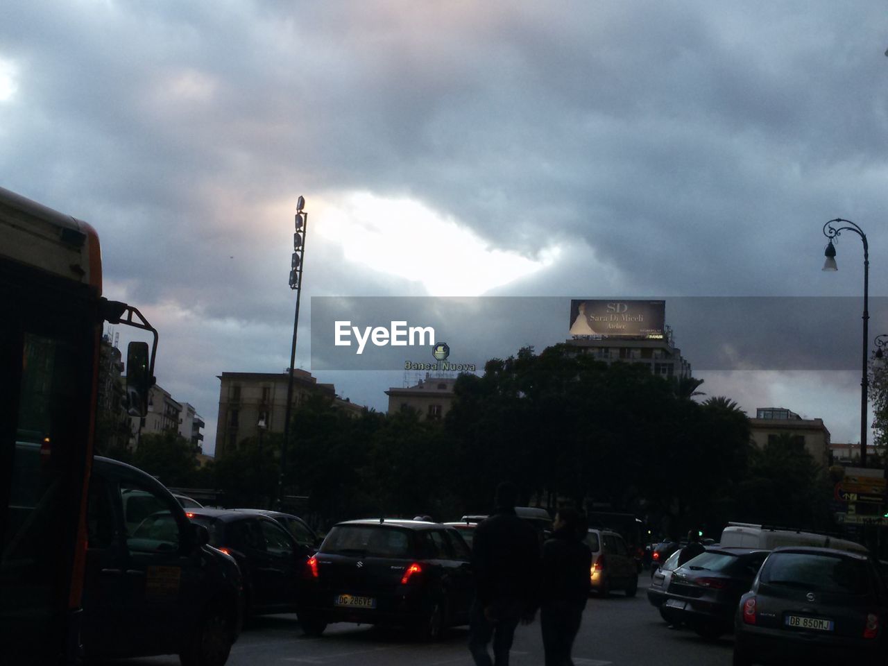 CARS ON STREET AGAINST CLOUDY SKY