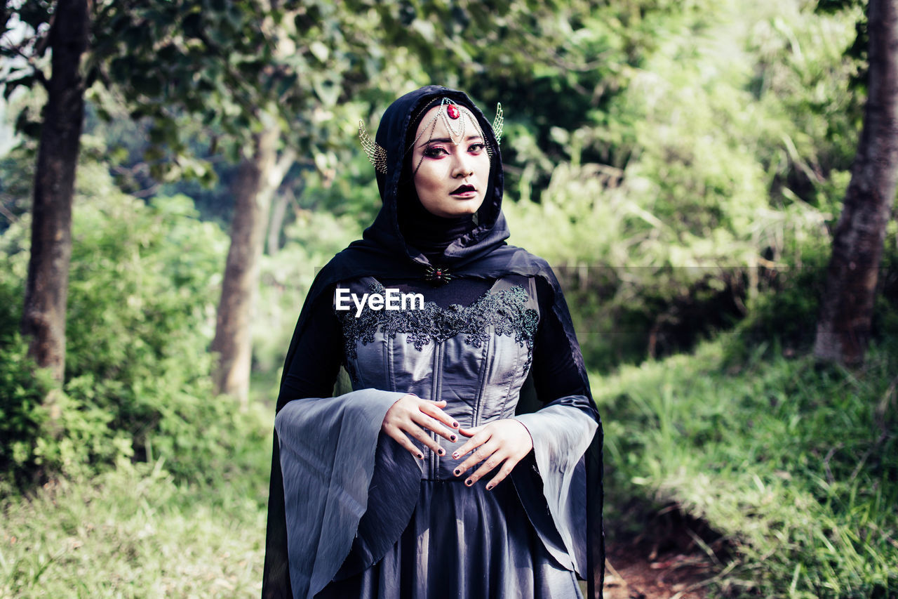 Young woman wearing witch costume while standing outdoors