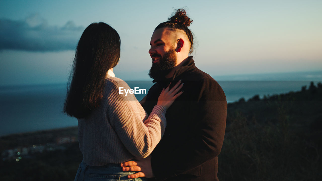 Engaged couple embrace at blue hour