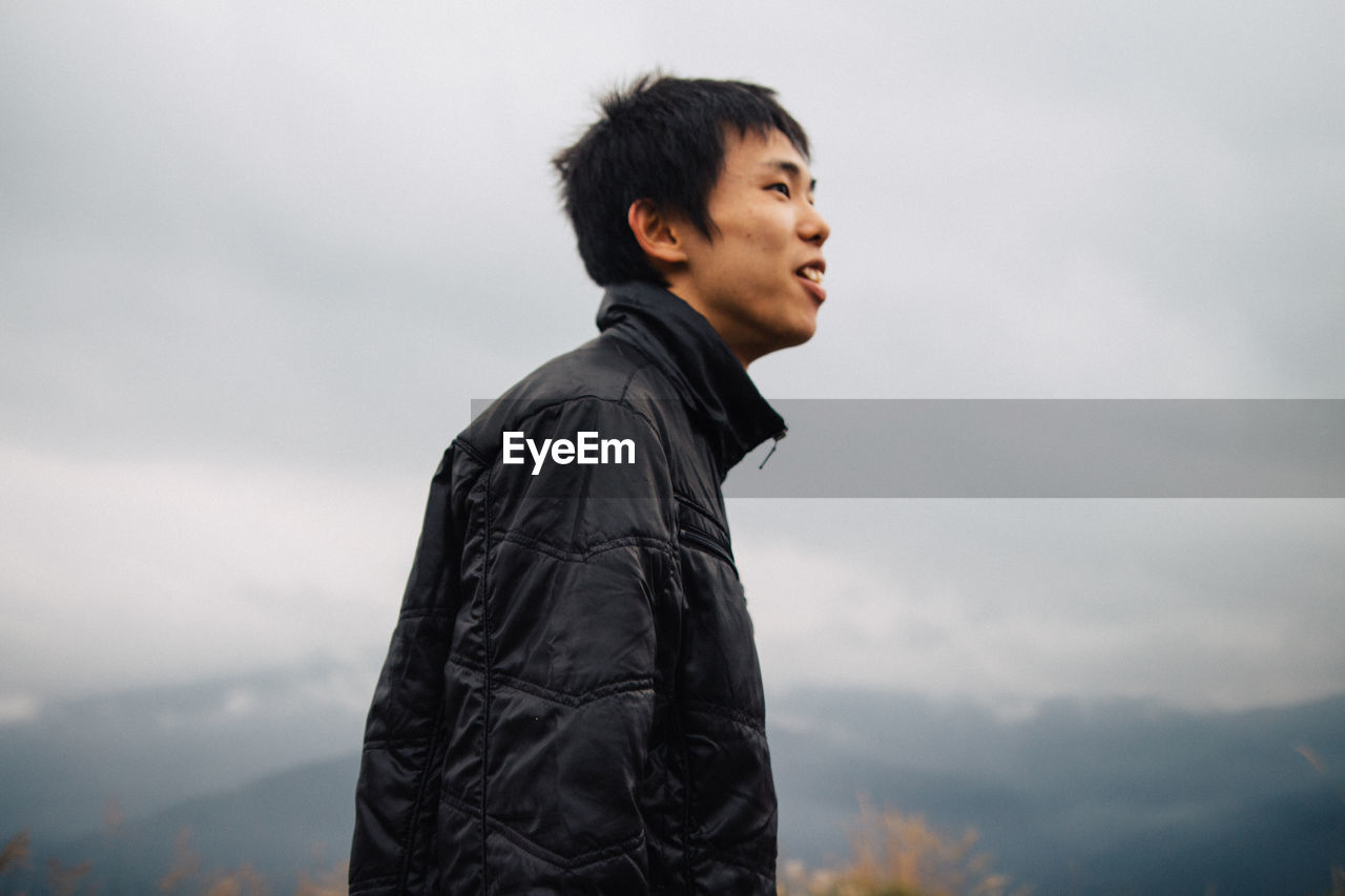 Portrait of man standing against sky