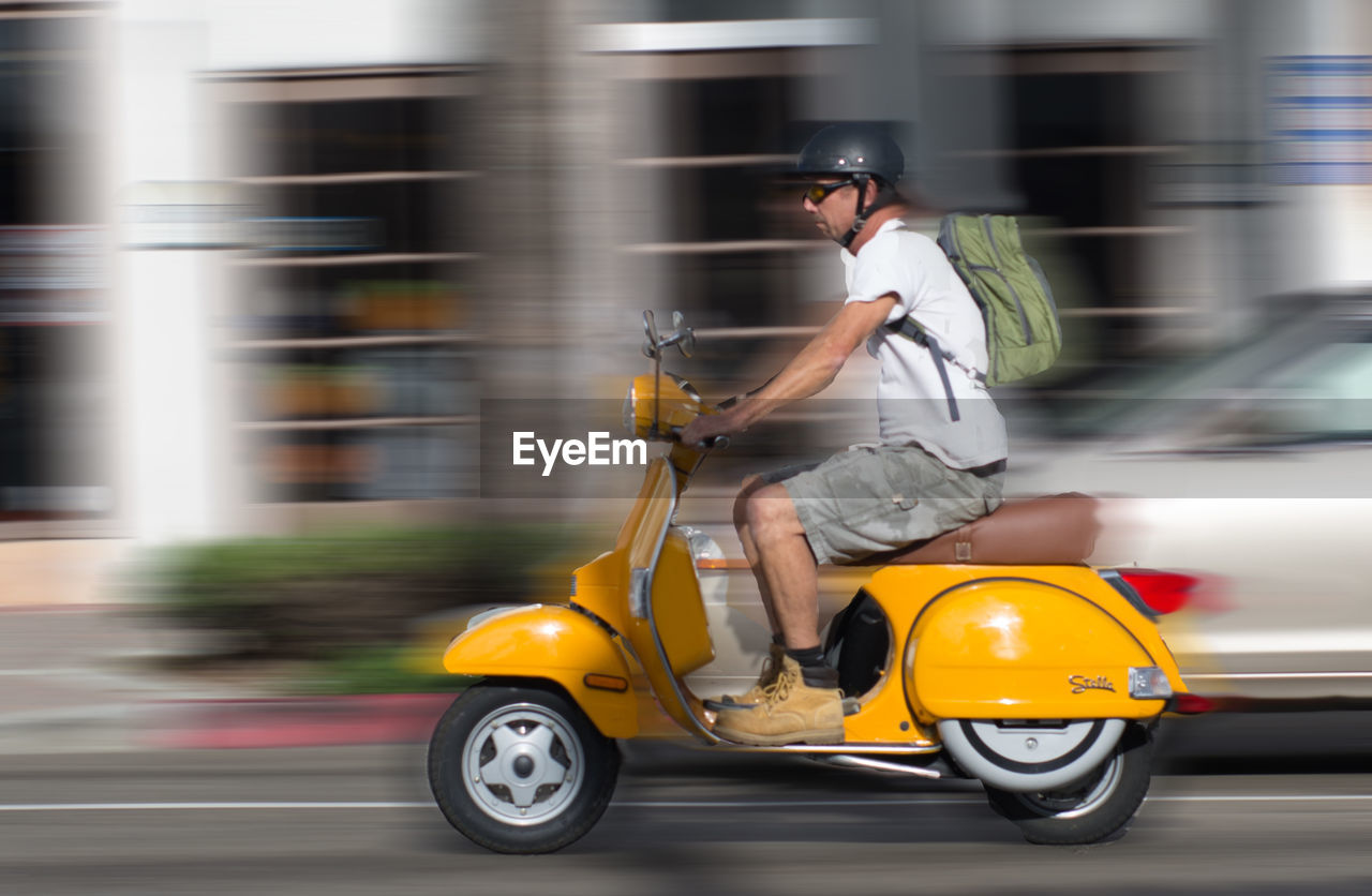 BLURRED MOTION OF MAN WALKING ON ROAD