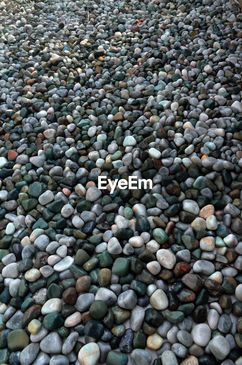 HIGH ANGLE VIEW OF PEBBLES ON GROUND