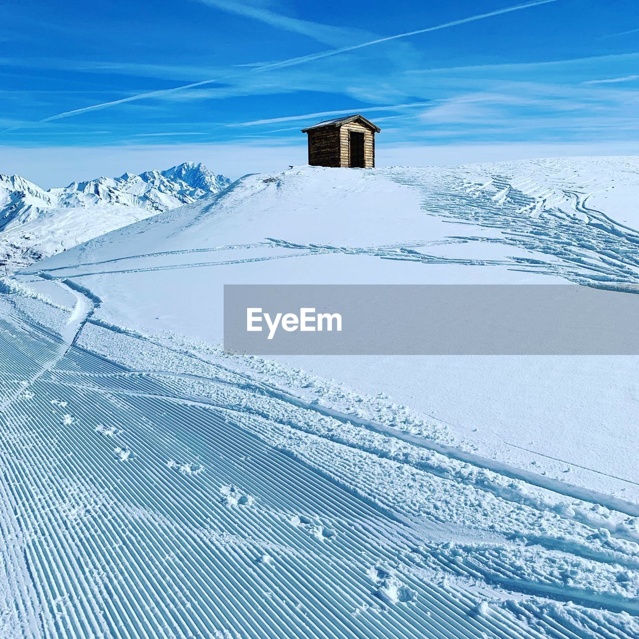 Scenic view of snow covered mountain against blue sky