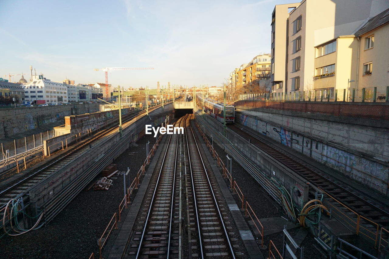 High angle view of subway tracks amidst buildings in city while sunset