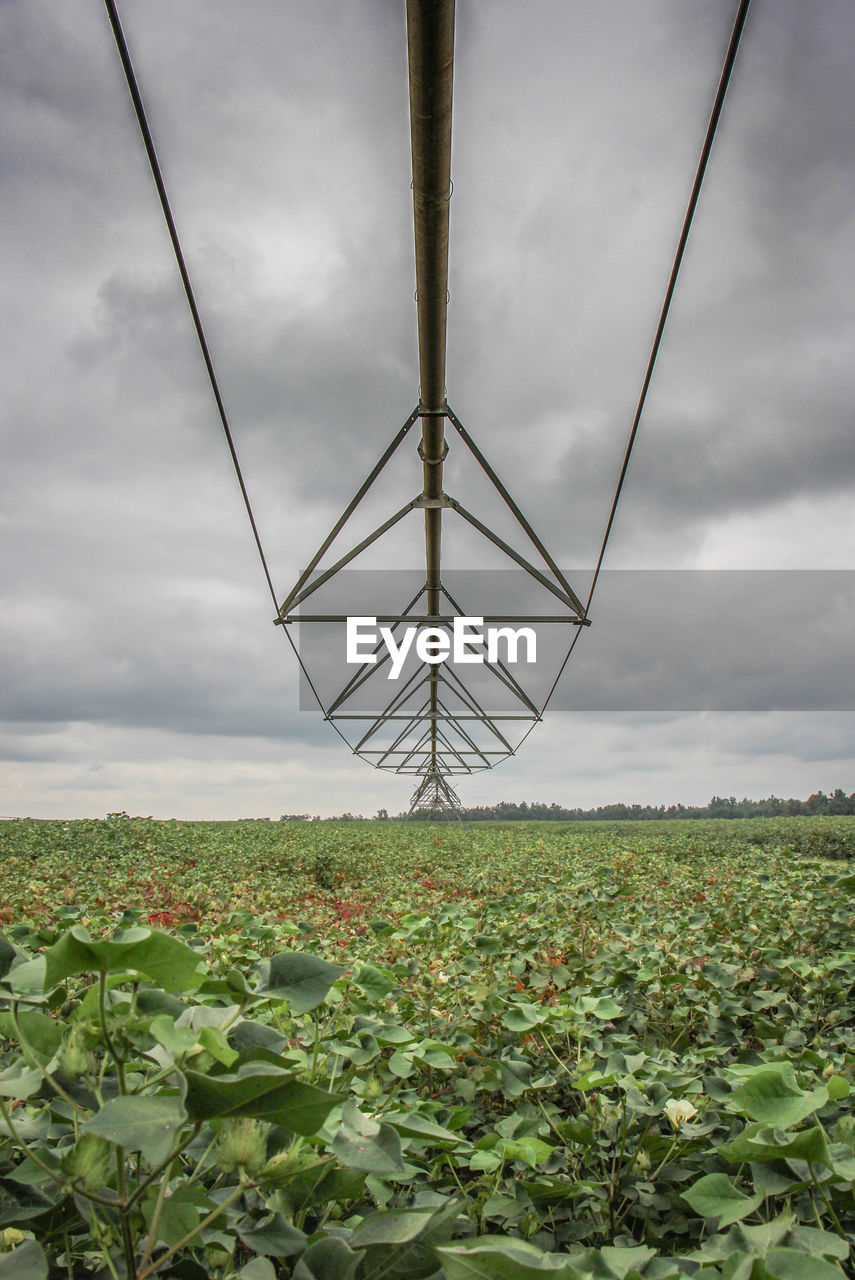 View of field against cloudy sky