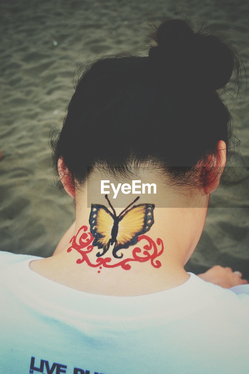 High angle view of tattoo on woman neck