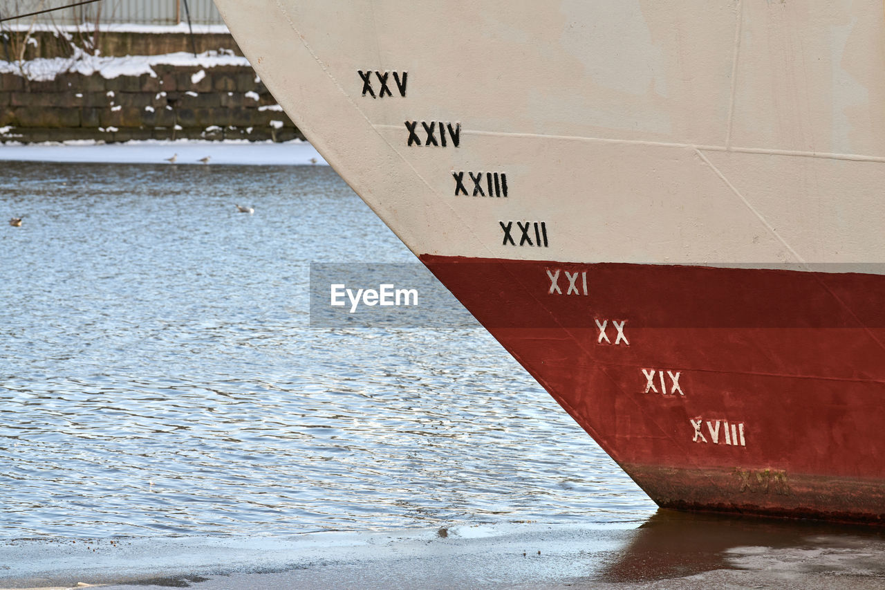 Old ship draft on hull, scale numbering. distance between waterline and bottom keel. ship in water.