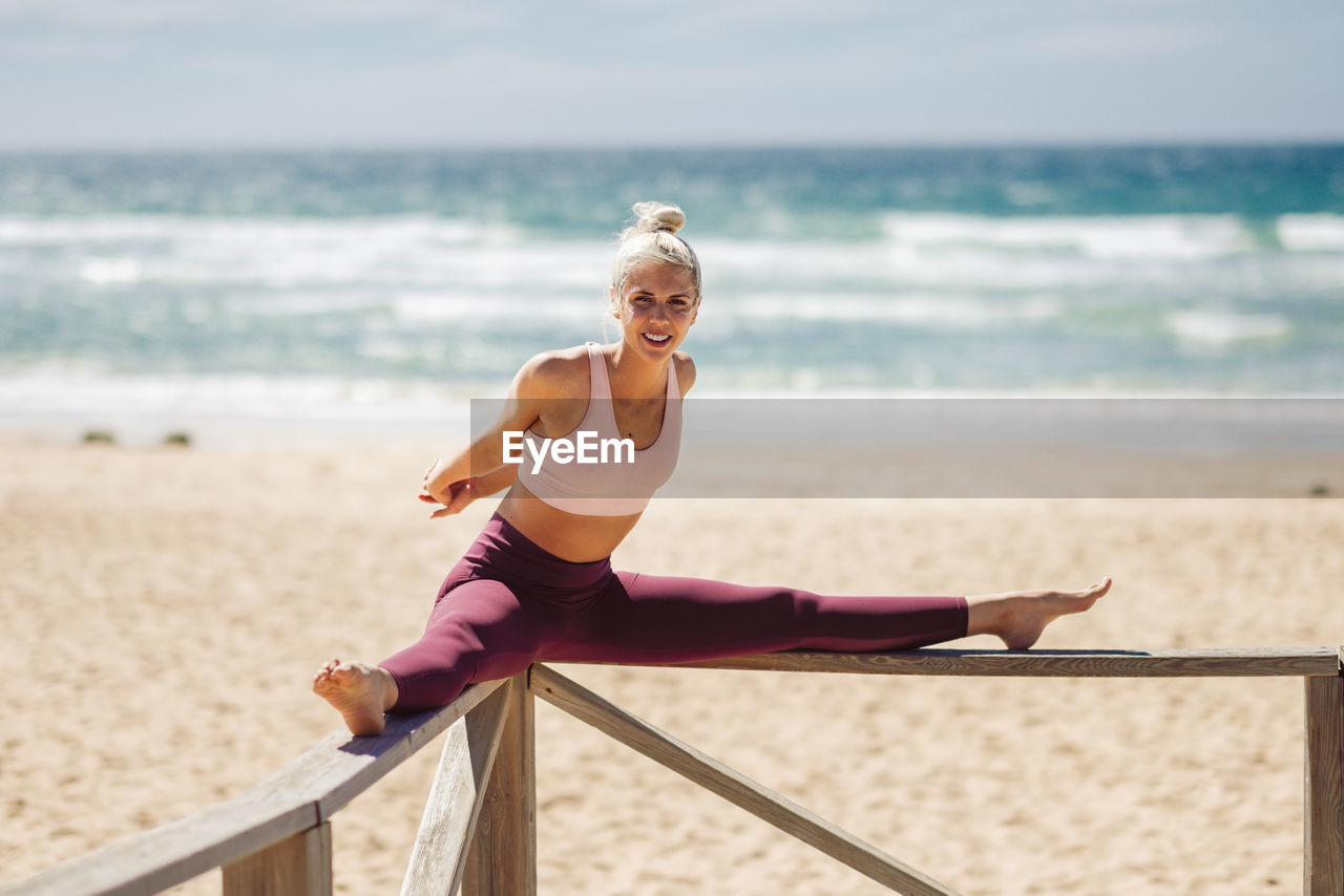 Portrait of young woman exercising at beach