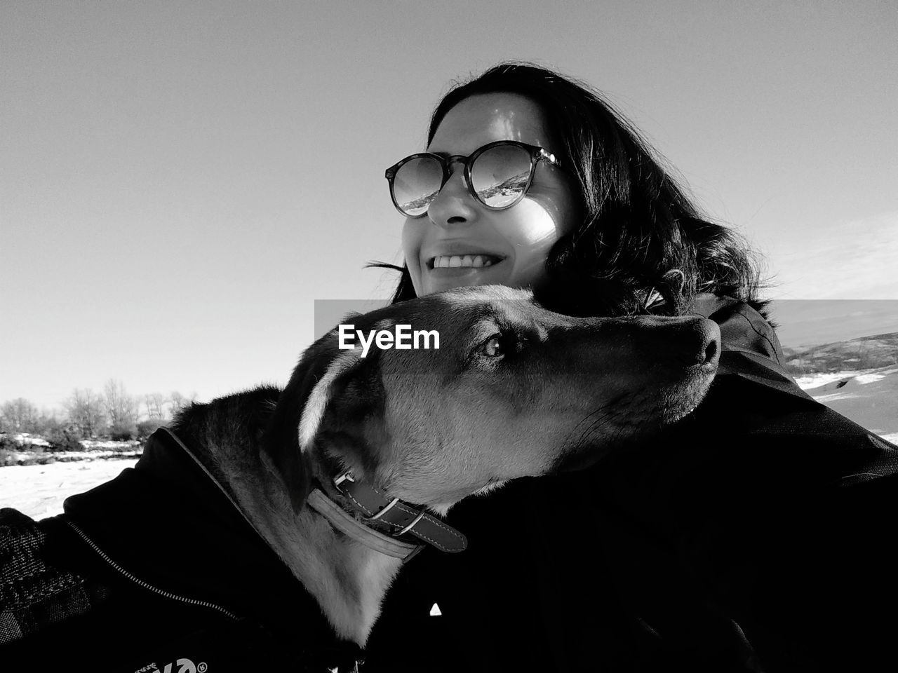 Close-up of woman with dog against sky