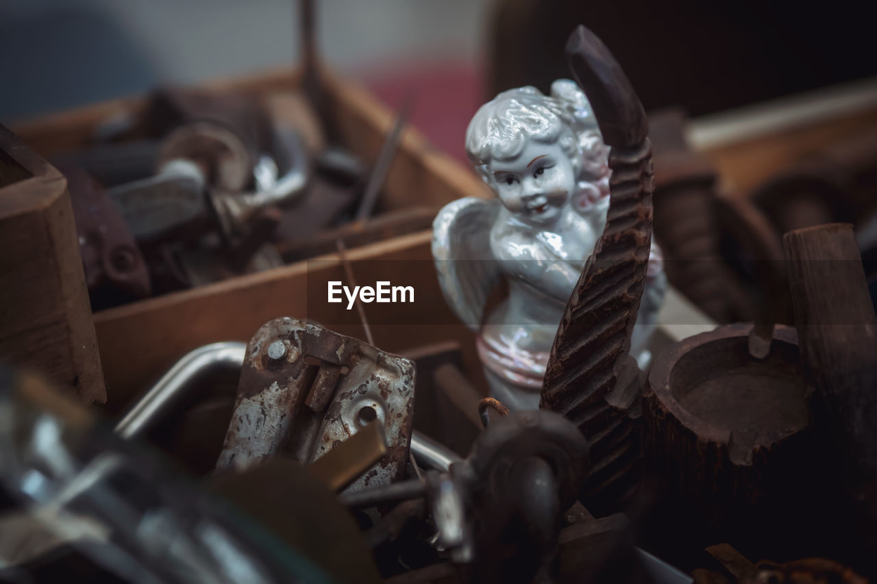 High angle view of statue amidst rusty metal in box