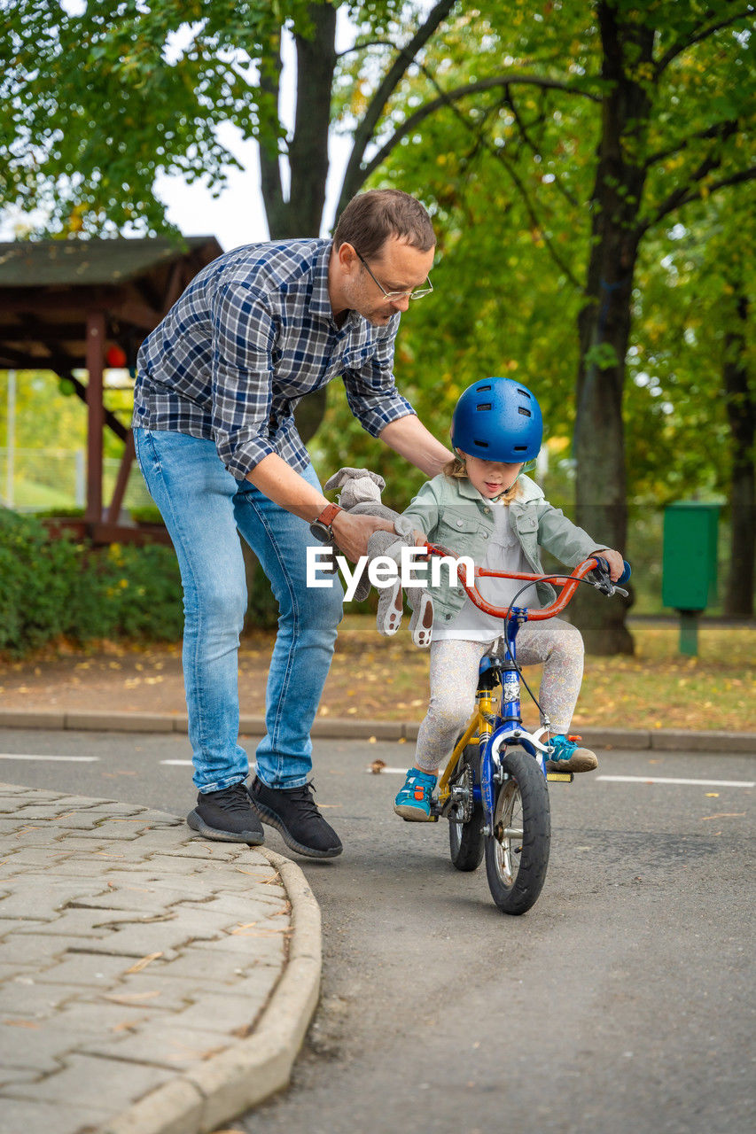 rear view of boy riding bicycle on road