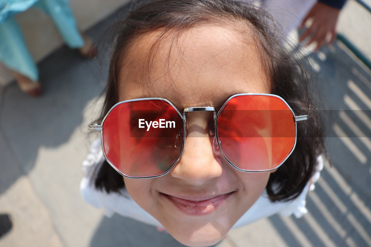 High angle close up portrait of a smiling girl with sunglasses