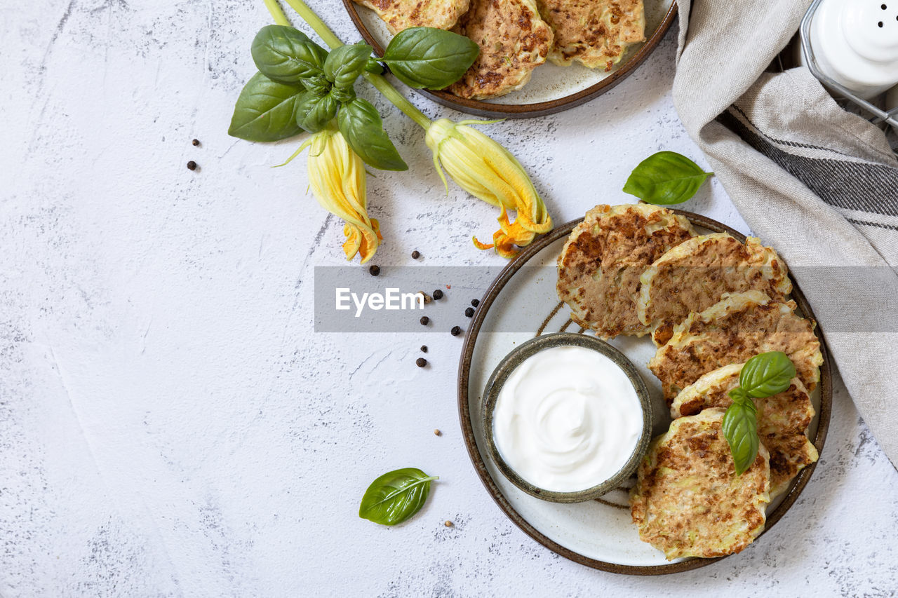 Zucchini fritters. vegetarian zucchini pancakes with cheese, served with sour cream. healthy food