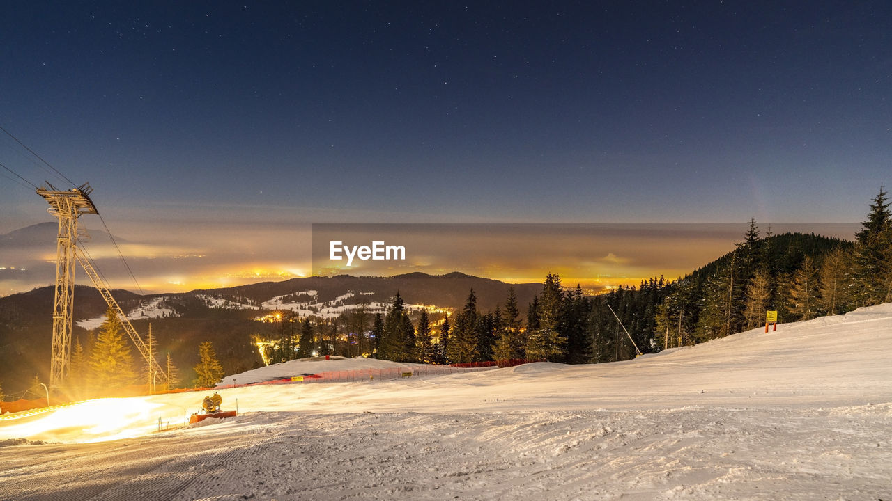 Scenic view of snow covered mountains against sky at night