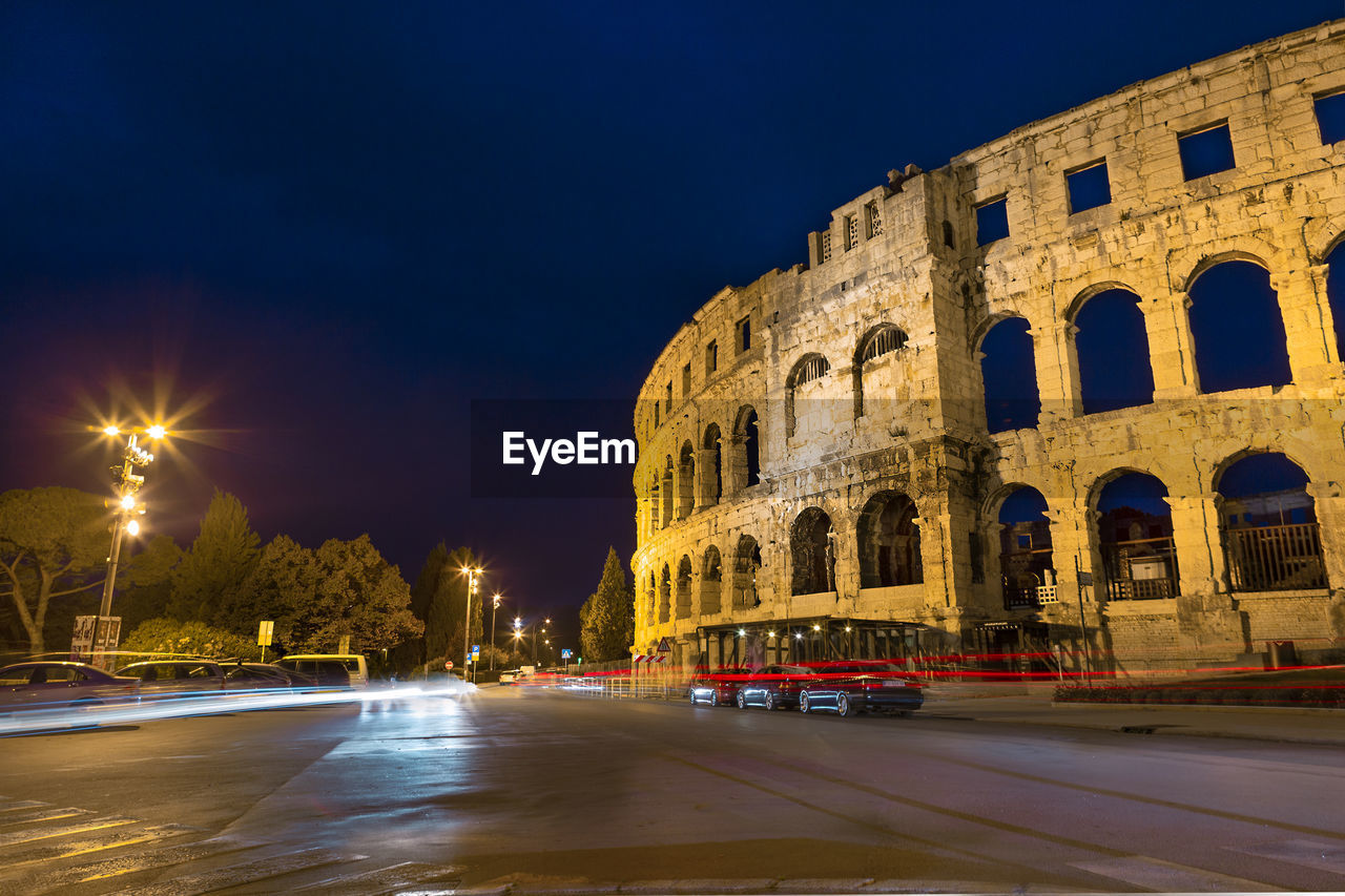 VIEW OF ILLUMINATED STREET AT NIGHT