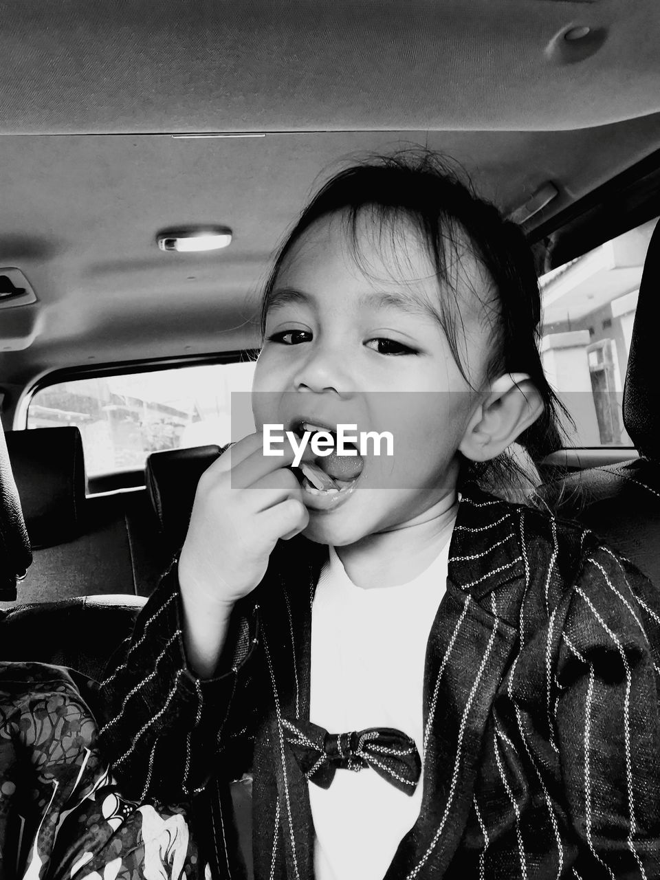 Portrait of cute girl sitting in car