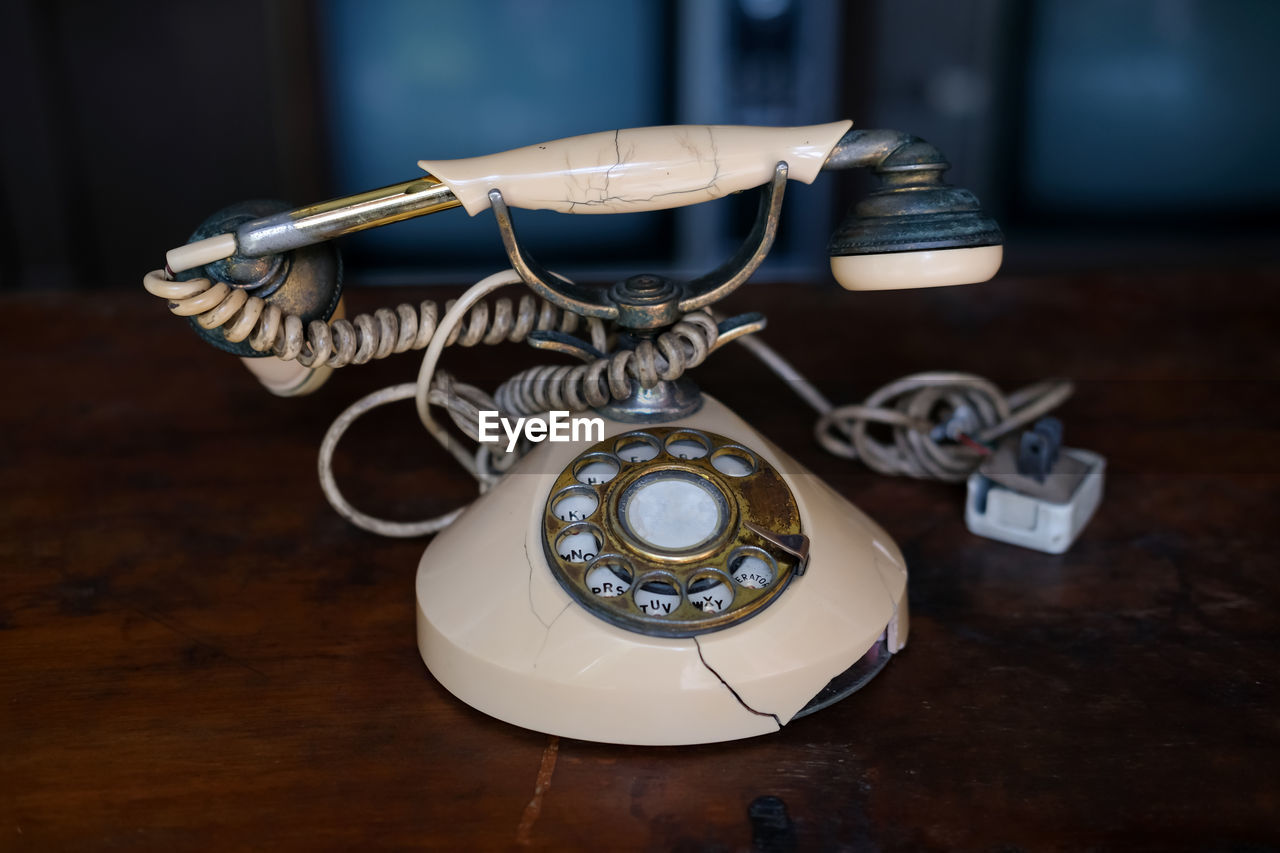 corded phone, telephone, retro styled, technology, landline phone, indoors, table, rotary phone, no people, communication, nostalgia, telephone receiver, black, history, the past, white, focus on foreground, close-up, still life