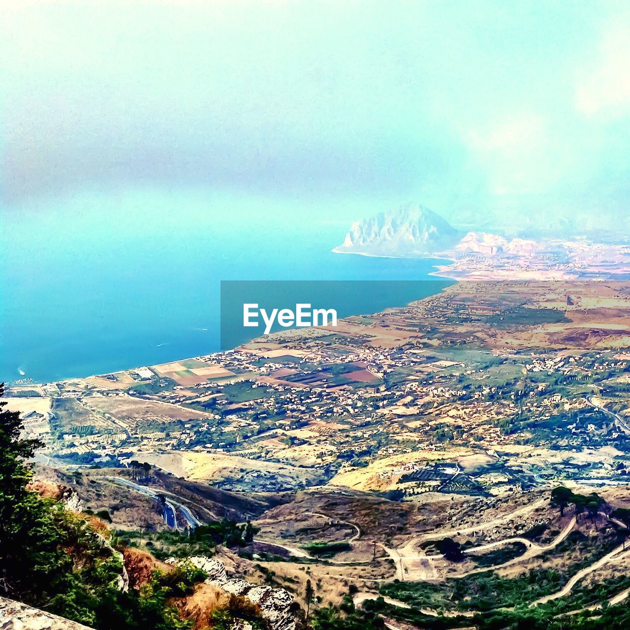 AERIAL VIEW OF CITYSCAPE AGAINST CLOUDY SKY