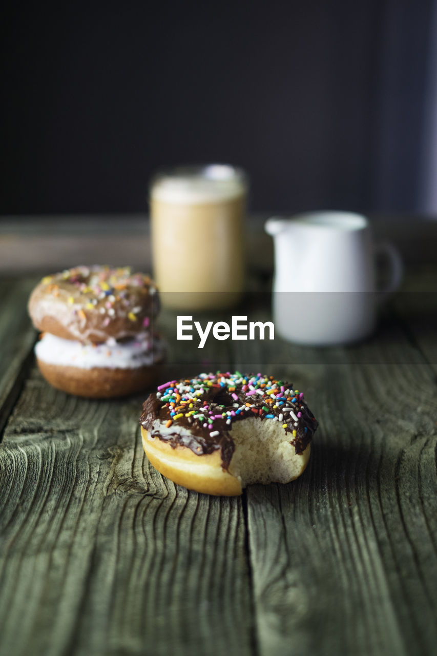 Close-up of donuts and drinks on wooden table