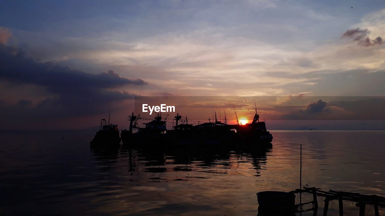 SILHOUETTE SHIP IN SEA AGAINST SKY AT SUNSET