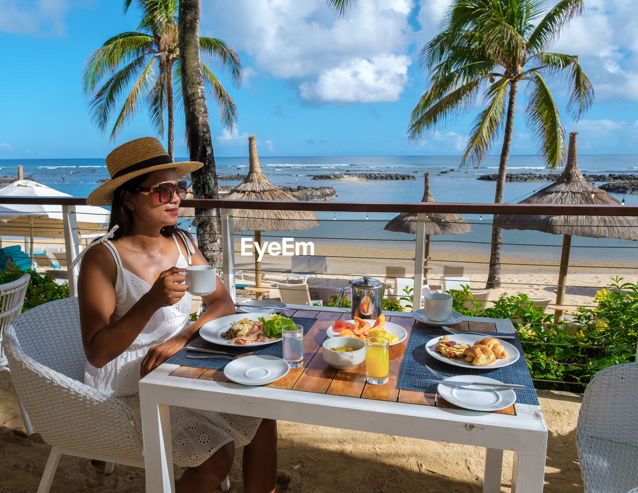 rear view of woman having breakfast at beach