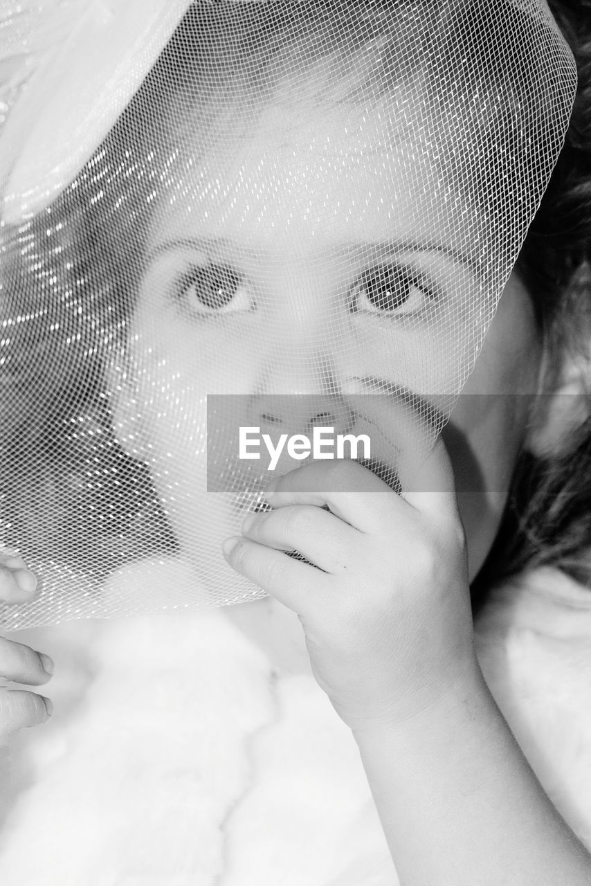 Close-up of girl seen through net