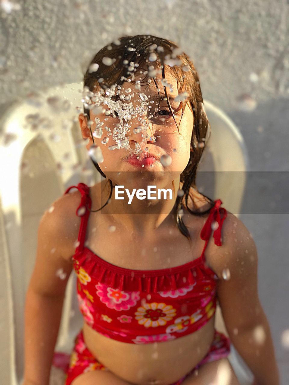 Close-up of girl spraying water from mouth