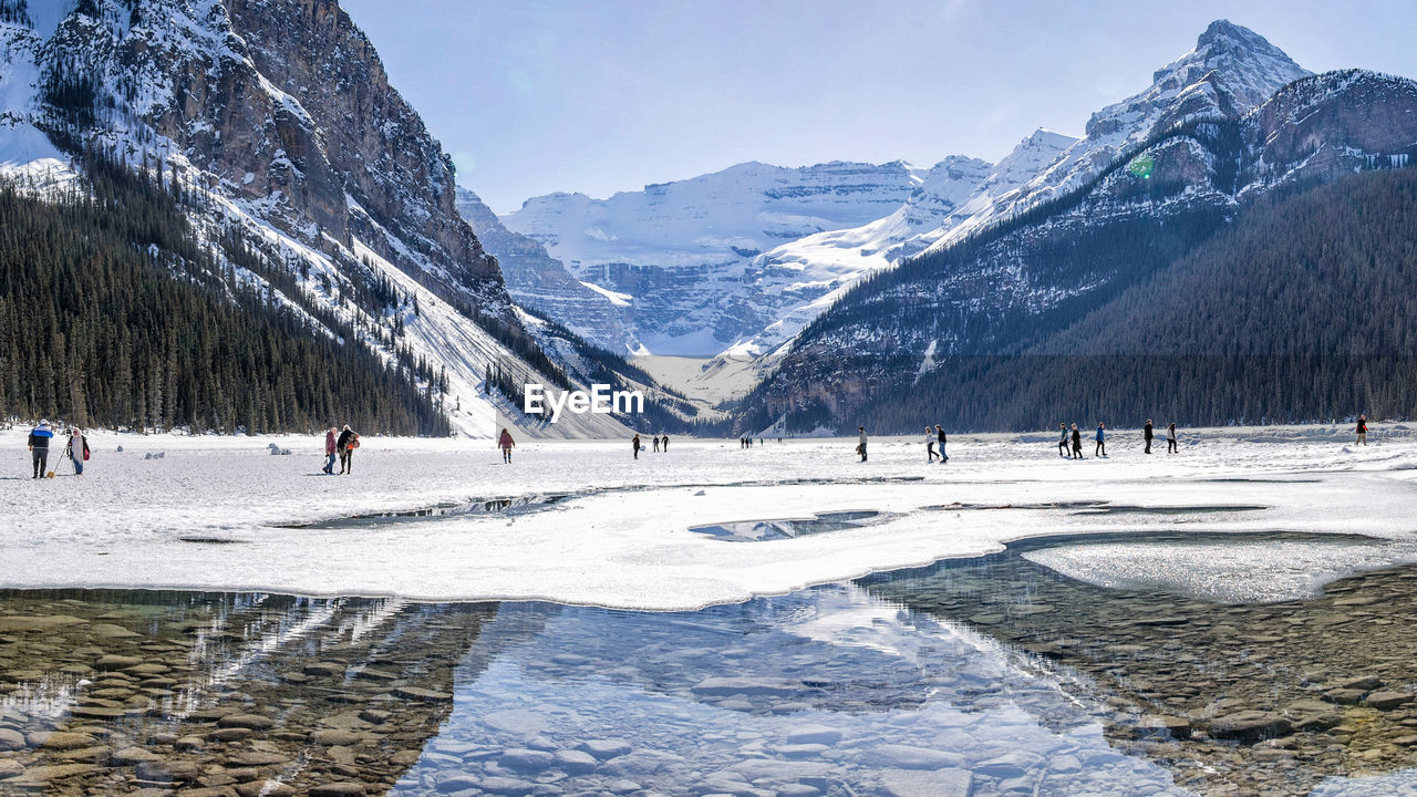 People on snow field against mountains 