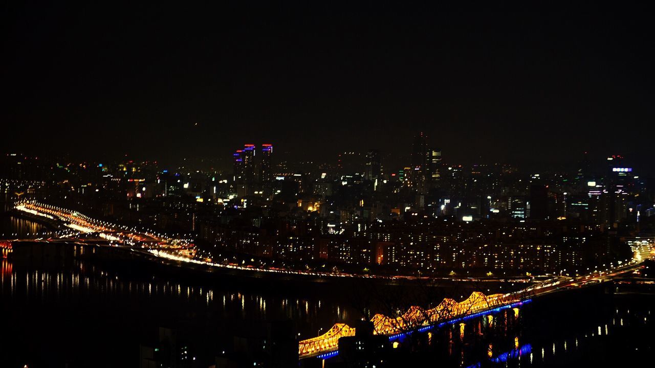 ILLUMINATED CITYSCAPE AGAINST SKY