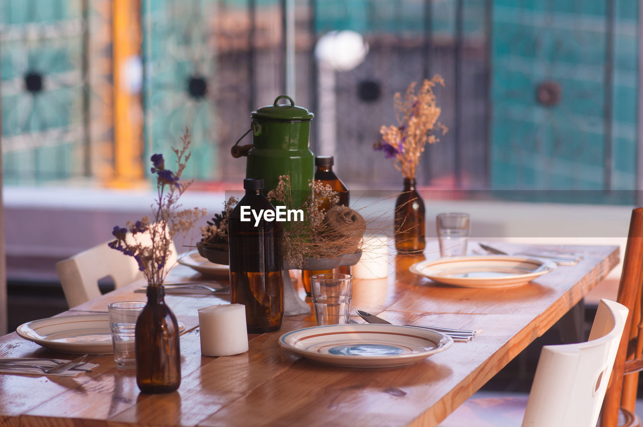 Plates arranged on dining table by window