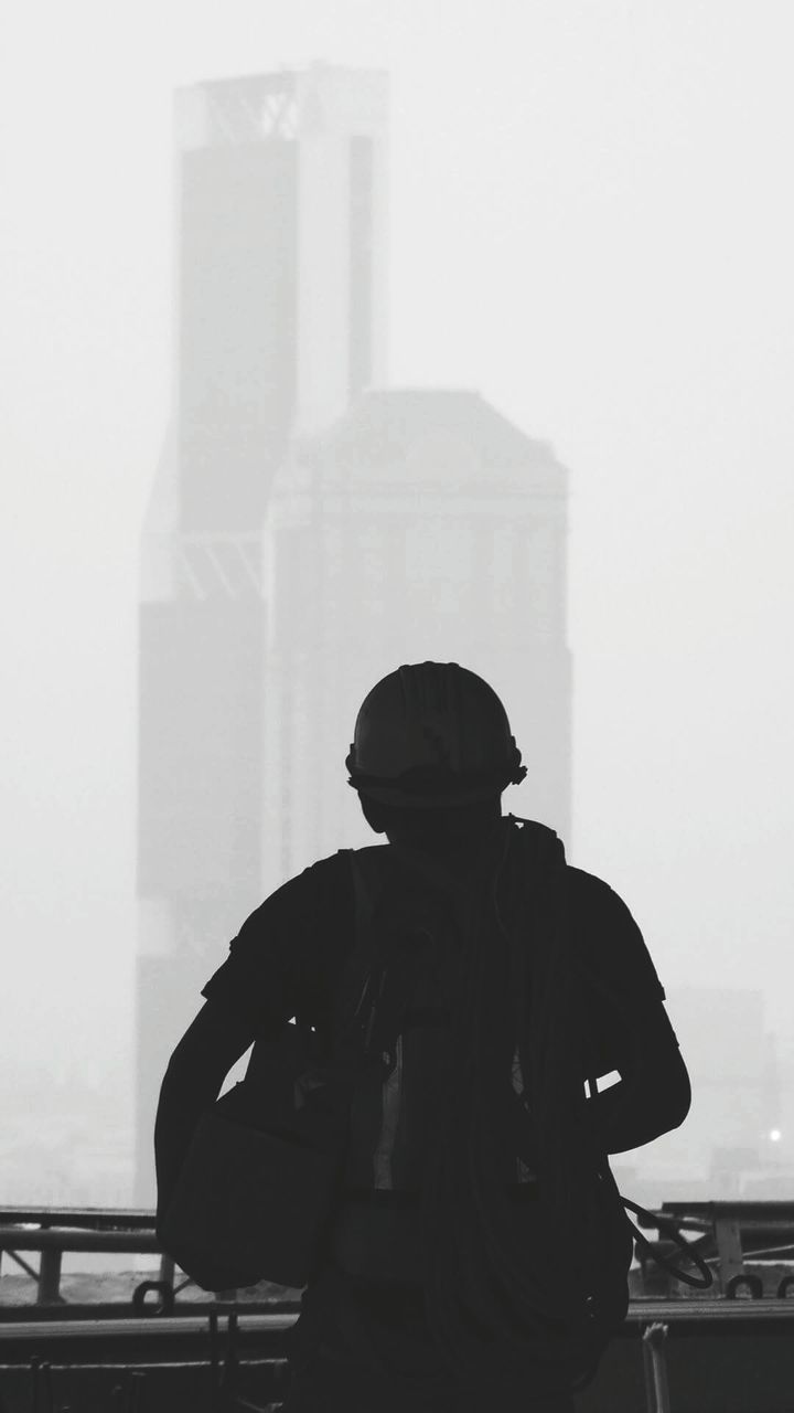 Rear view of man standing against buildings