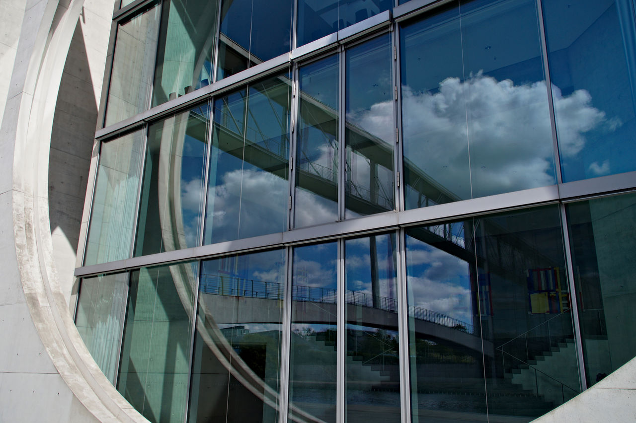 Low angle view of glass building against sky