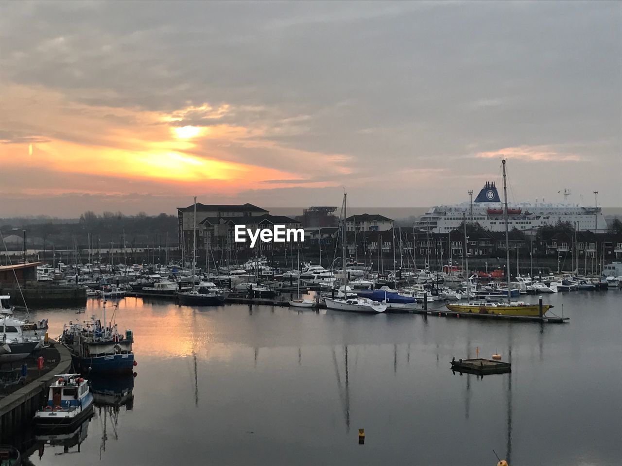 Sailboats moored at harbor