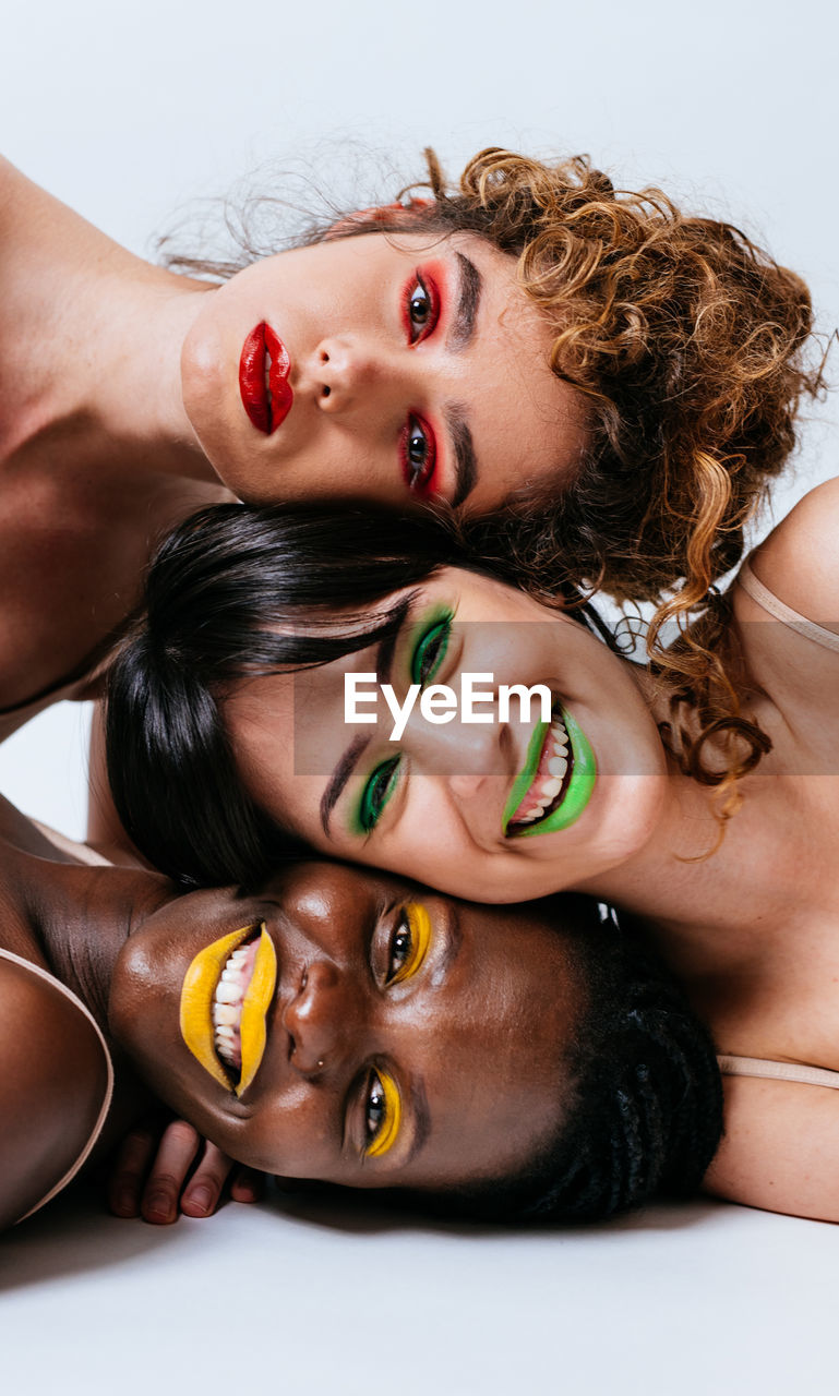 Portrait of women lying against white background