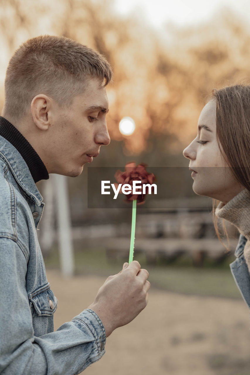 Young man and woman blowing on a wind toy, ecology concept