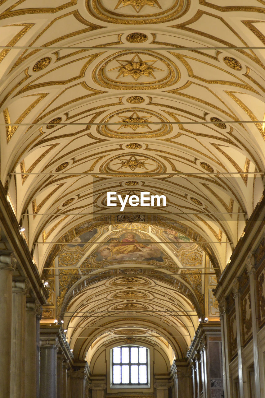 LOW ANGLE VIEW OF ORNATE CEILING IN HISTORIC BUILDING