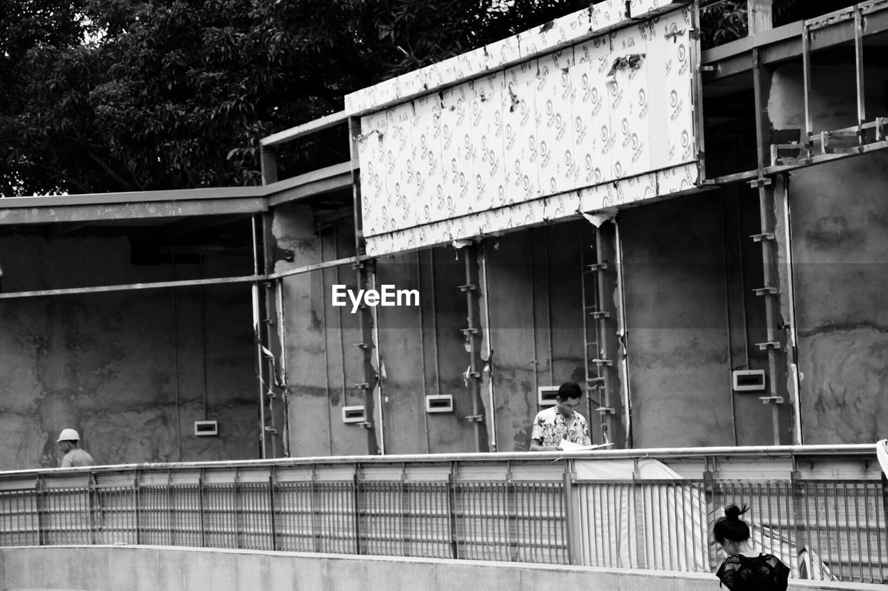 MAN STANDING IN FRONT OF WALL