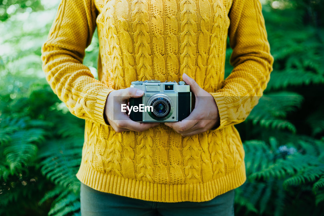 Woman photographing with yellow camera