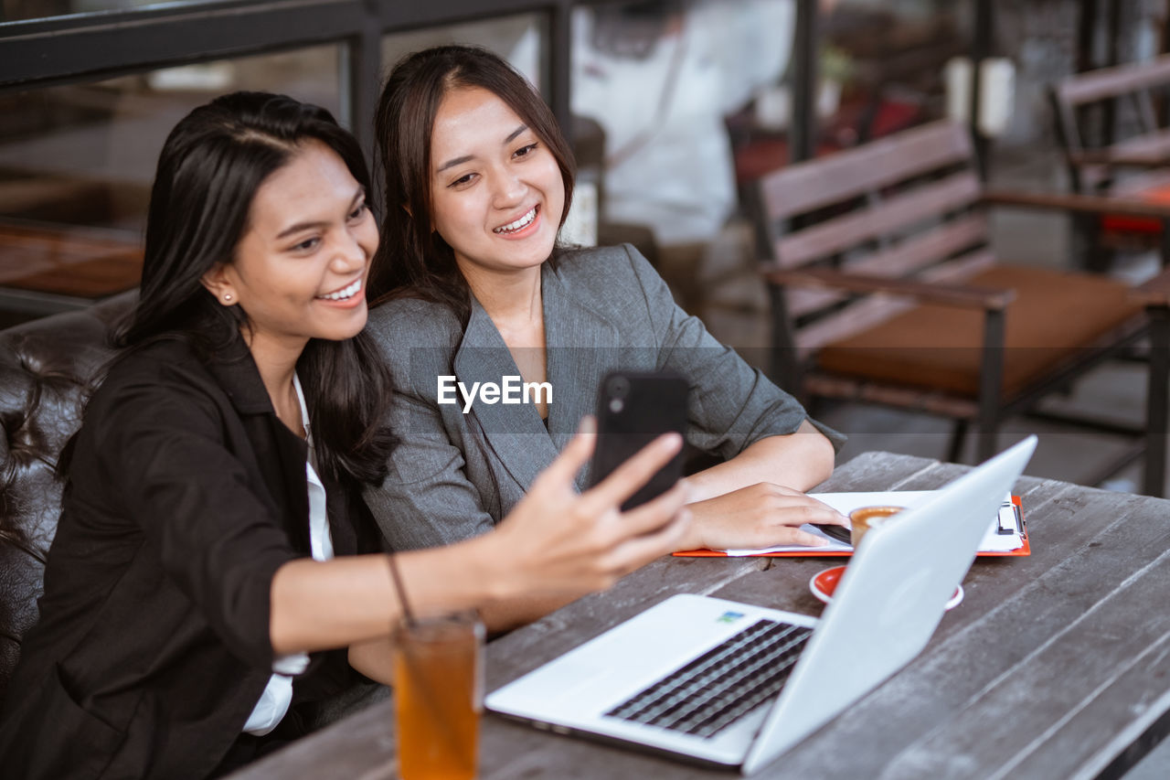 portrait of young businesswoman using laptop while sitting at office