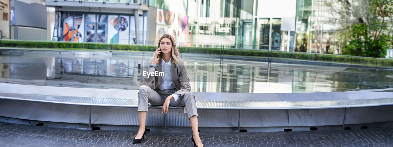 side view of woman sitting on railing