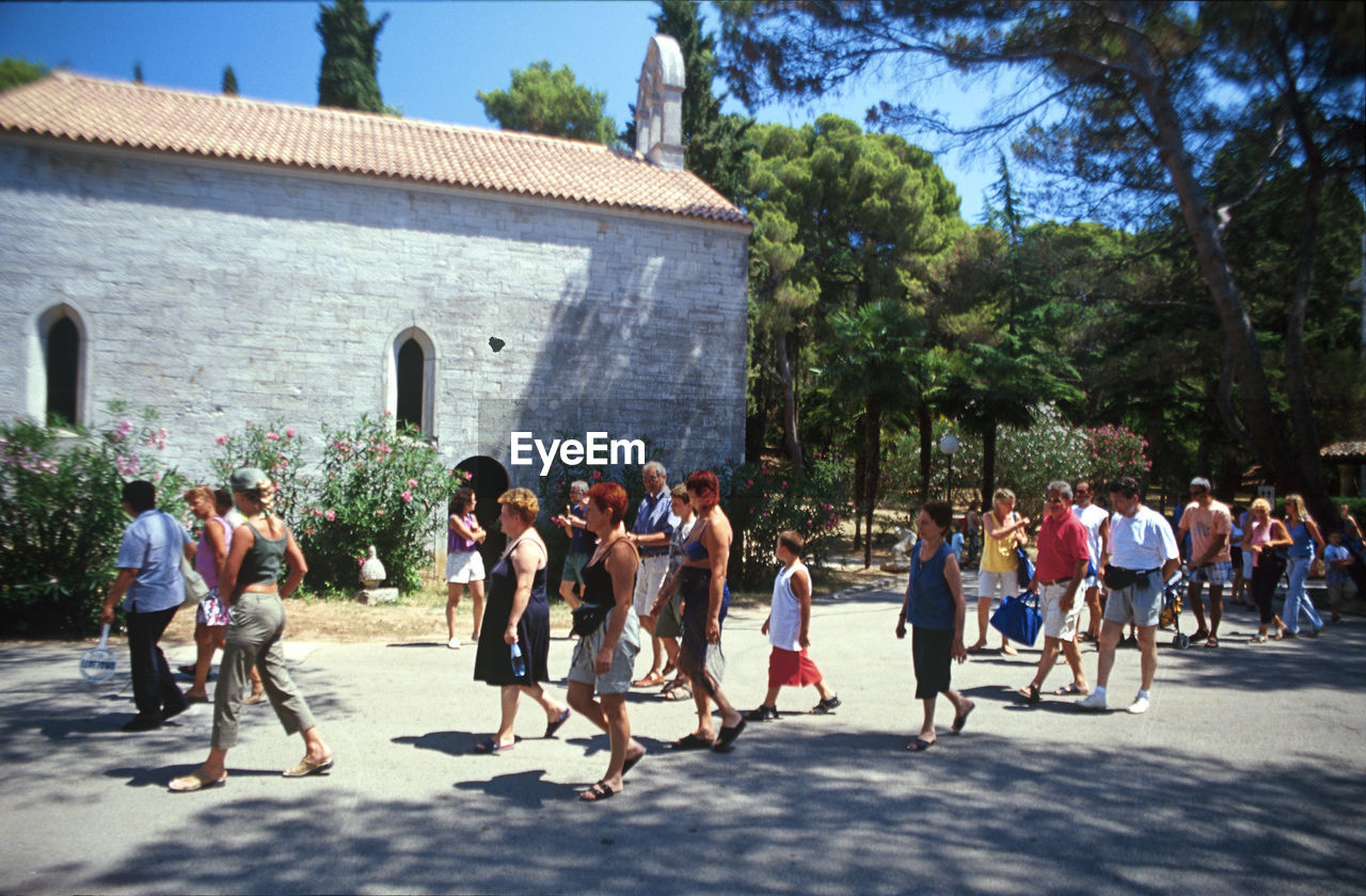 GROUP OF PEOPLE AGAINST BUILDING