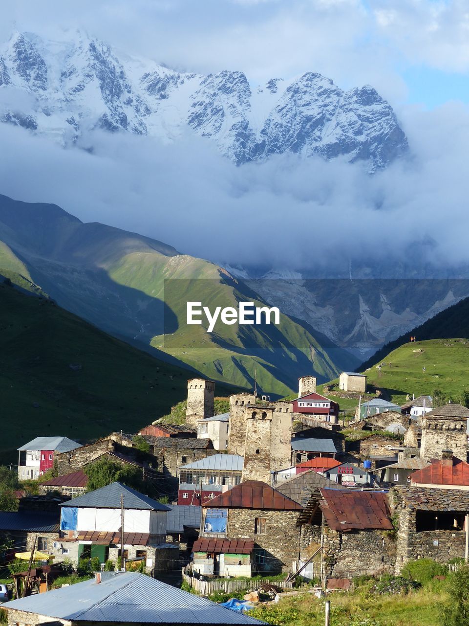 Aerial view of townscape and mountains against sky